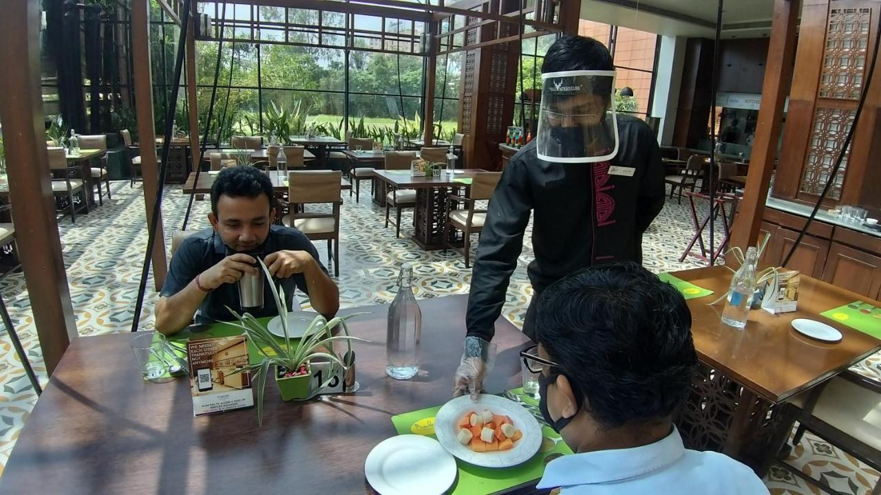 The Orchid Hotel Hinjewadi Pune Exterior foto A restaurant in India with a waiter wearing a face shield